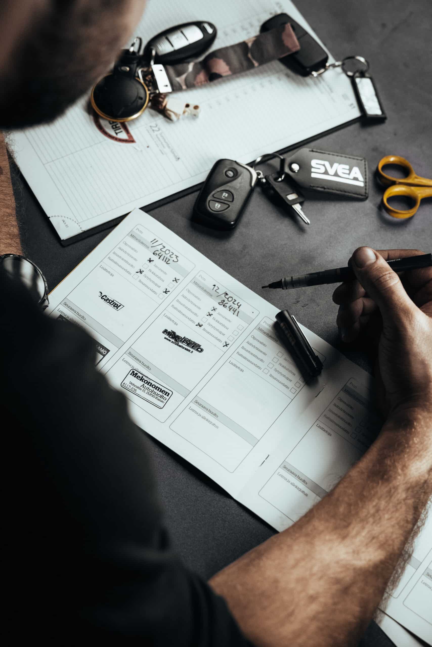 MaxSpeed Service – Autohuolto Raisio. Mekaanikko täyttää auton huoltokirjaa.